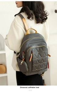 Detalle de tela Oxford gris acolchada con remaches dorados y una pequeña bolsa