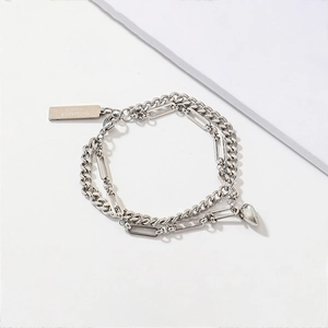 Detail of double-layer silver stainless steel heart bracelet with shimmer logo tag