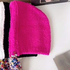 Detail of colorful knitted tassels on warm winter balaclava plush earflaps hat