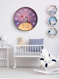 Detail einer Kinderwanduhr mit Astronauten-Motiv an einer weißen Wand im Kinderzimmer