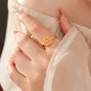 Vintage flower ring with gold textured petals and white zircon stones on woman's hand