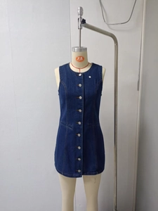Dettaglio mini abito in denim monopetto con girocollo senza maniche e tasche