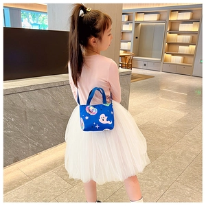 Blue kids crossbody bag with cartoon ghost and candy patterns shown in use by a child