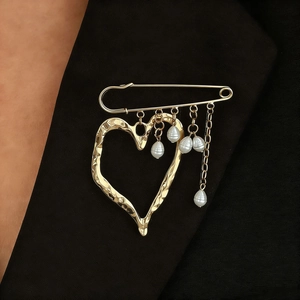 Golden heart brooch with safety pin design, hammered texture and pearl tassels