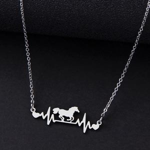Stainless steel heartbeat necklace with horse silhouette and heart pendant on black surface