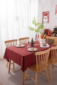 Classic red plaid Christmas tablecloth with tassels in a festive holiday dining setting