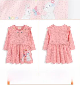 Detail of pink polka dot girl's dress featuring floral embroidery and rabbit applique