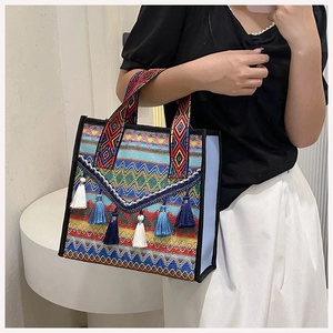 Detail of bohemian ethnic tote bag featuring colorful woven patterns and tassel accents