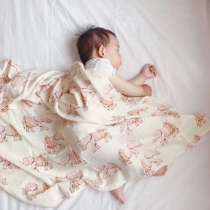 Detailed texture of muslin bamboo cotton baby swaddle with pink elephant pattern