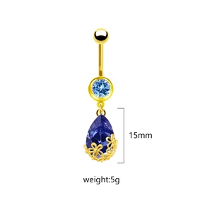 Dettaglio del piercing all'ombelico dorato con gemma blu a goccia e misura 15mm