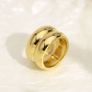 Detailed view of wide double-layer gold plated stainless steel ring on textured background
