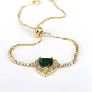 Detail of adjustable gold bracelet featuring heart emerald zircon and sliding closure