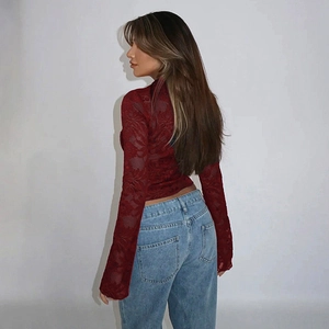 Detail of burgundy lace top with elegant semi-sheer texture and slim fit sleeves