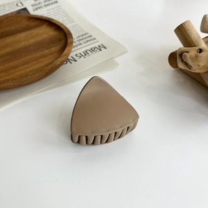 Detailed view of a triangle hair claw clip in matte coffee brown on a white surface
