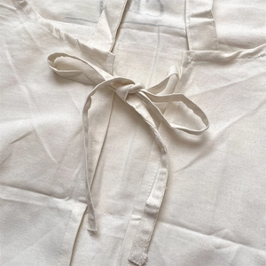 Detail of minimalist cotton linen apron showing natural texture and adjustable waist tie