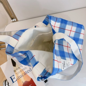 Blue and white plaid canvas tote bag interior with inner pocket and woven label detail