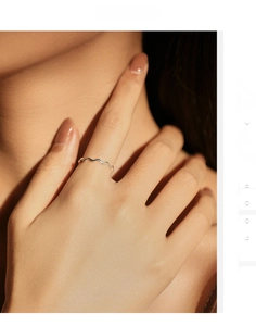 Close-up of minimalist wave ring in S925 sterling silver on woman's finger