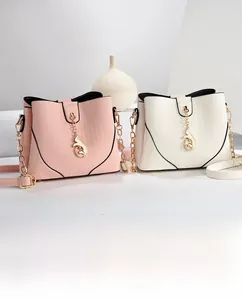 Close-up of leather bucket bags with vertical stripes and fish charm in pink and beige