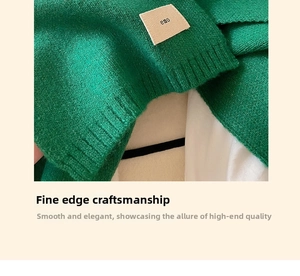 Close-up of green knitted scarf texture with a stylish 'emo' square fabric label