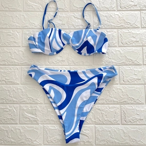 Detail of blue and white abstract fluid swirl pattern on high cut bikini swimwear