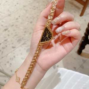 Montre bracelet en chaîne dorée avec un cadran triangulaire noir élégant porté au poignet