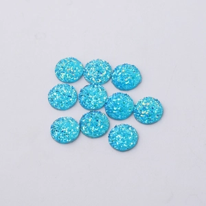 Macro detail of 12mm blue resin drusy cabochons with sparkling mineral texture for DIY crafts
