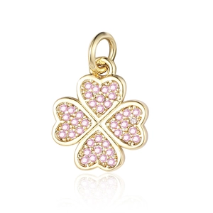 Macro shot of gold four-leaf clover pendant with sparkling pink cubic zirconia stones