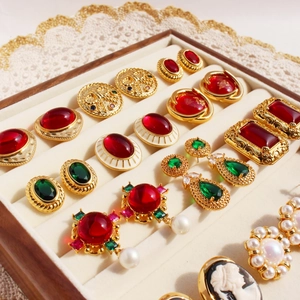 Vintage style jewelry set with emerald green and ruby red stones in a velvet box