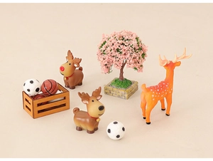 Miniature dollhouse scene with pink cherry tree, brown reindeer, and sports ball box