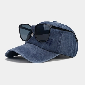 Close-up view of a vintage denim baseball cap with integrated black flip-up sunglasses