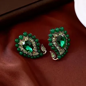Boucles d'oreilles vintage vert goutte avec cristaux sur fond de soie luxueux sombre