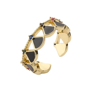 Macro shot of gold shell ring with black enamel triangles and colorful gemstones