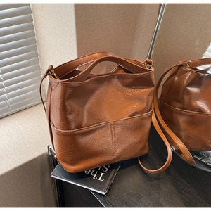 Detailed view of the caramel brown bucket bag with vintage wrinkled oil wax leather texture