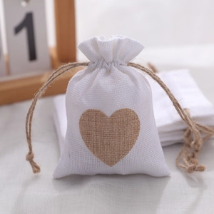 White linen Christmas drawstring gift bag featuring a brown heart patch and jute rope