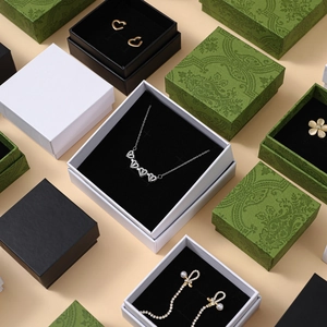 Flat lay of vintage green embossed jewelry boxes and minimalist gift packaging sets