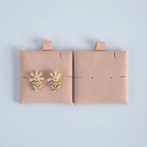 Close-up of pearl flower earrings with gold metal base on pink velvet display card