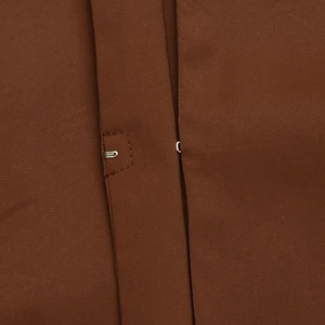 Close-up of metal hook-and-eye fastener on brown fabric of a two-piece summer set