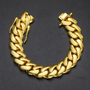Detailed macro view of a 10mm gold cuban link chain bracelet with a butterfly safety clasp