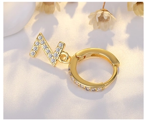 Close-up of golden S925 silver letter N earrings with white zircon micro-pave crystals