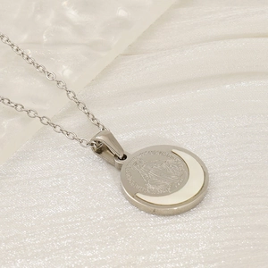 Macro detail of silver Virgin Mary medallion necklace with white mother of pearl inlay