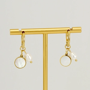 Golden geometric hoop earrings with white shell disc and pearl pendants on display