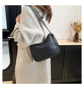 Fashionable black faux leather hobo shoulder bag styled on a model for everyday wear