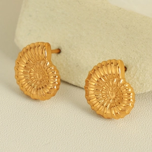 Vintage golden conch shell stud earrings with spiral texture on beige background