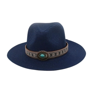 Détail d'un chapeau de paille bleu marine avec ruban bohème et pierre turquoise