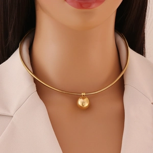 Minimalist gold ball spring necklace with snake chain worn by a model for a sleek look