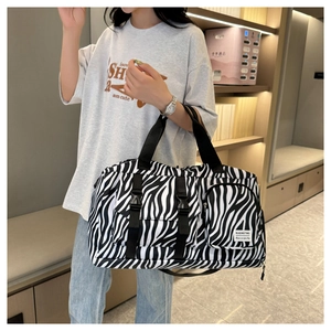 Zebra pattern duffel bag held by model showing large capacity and stylish handles