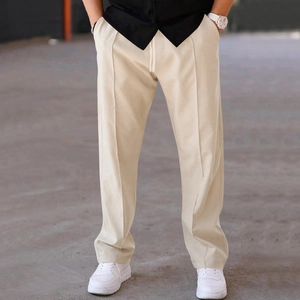 Detail of men's straight leg trousers featuring drawstring elastic waist and beige fabric