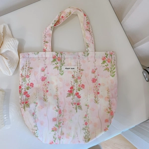 Gros plan détaillé du sac en coton rose à fleurs avec l'étiquette tissée Simple Wish