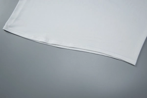 Gros plan détaillé sur les doubles coutures de l'ourlet d'une robe moulante blanche