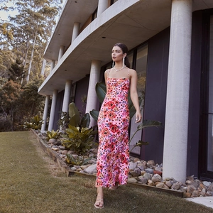 Detailed view of sweet floral maxi dress with orange flowers and flowy pink fabric